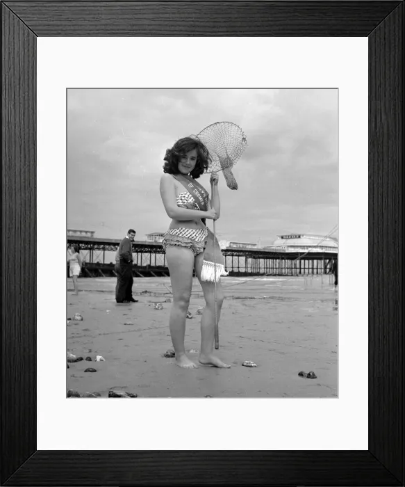 Framed Print : Beauty contest winner at Cromer, UK. seen here posing on the beach with net 26th