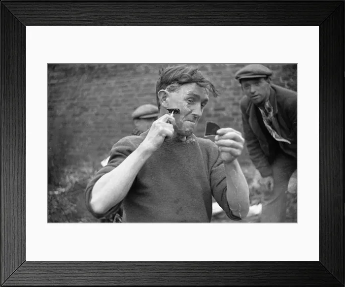 Framed Print : Tramp uses a fragment of a mirror to aid him in his shaving. Circa 1936 Framed Print : Tramp uses a fragment of a mirror to aid him in his shaving. Circa 1936