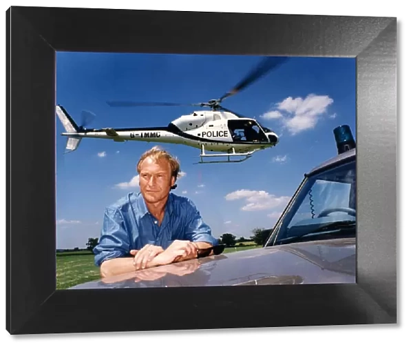 A helicoper hovers above the head of actor Nigel Le Vaillant in a field at Studley Grange