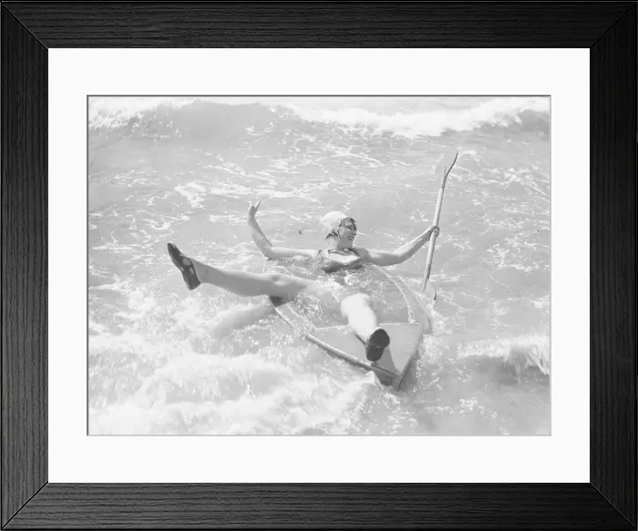 Framed Print : Woman playing in the surf with a canoe at Elmer Sands, West Sussex Framed Print : Woman playing in the surf with a canoe at Elmer Sands, West Sussex