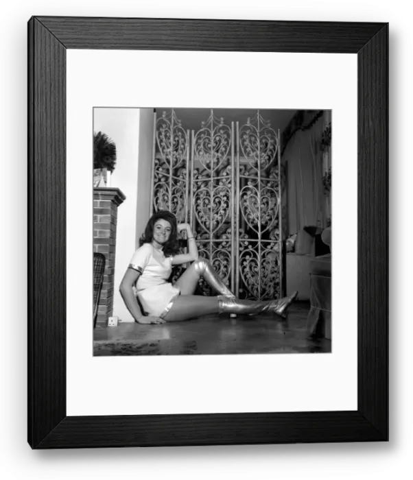 Framed Print : Model Susie King poses wearing a mini dress and knee high boots