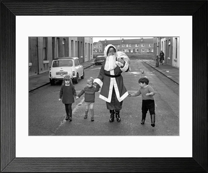 Framed Print : An elderly woman dressed as Santa Claus on her way to an engagement accompanied by