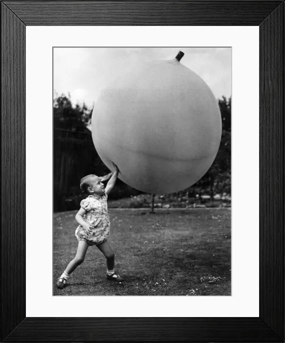 Framed Print : Little boy. big ball With very little effort I can hold up this ball Framed Print : Little boy. big ball With very little effort I can hold up this ball