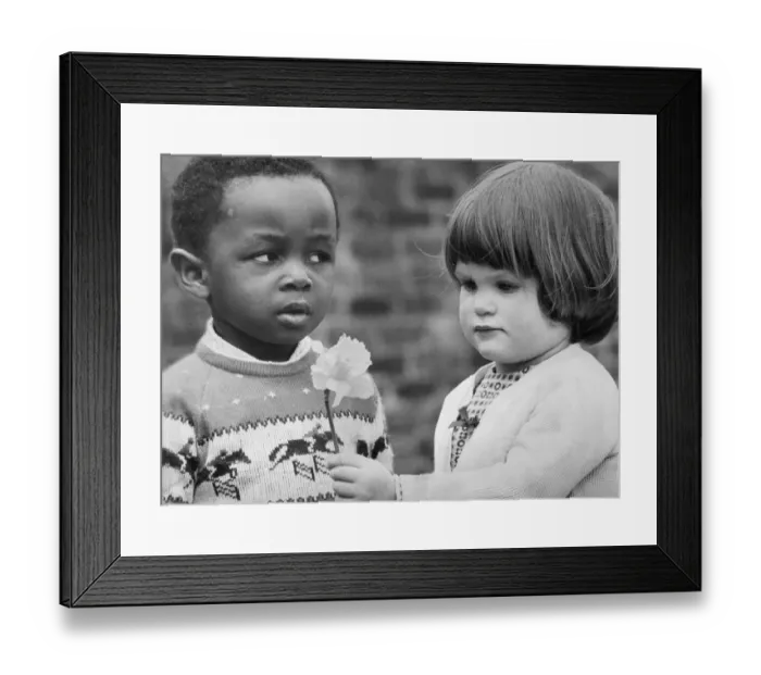 Framed Print : Chloe Rigby tries to present a flower to Frederick Omed at Osbourne Road Day Nursery