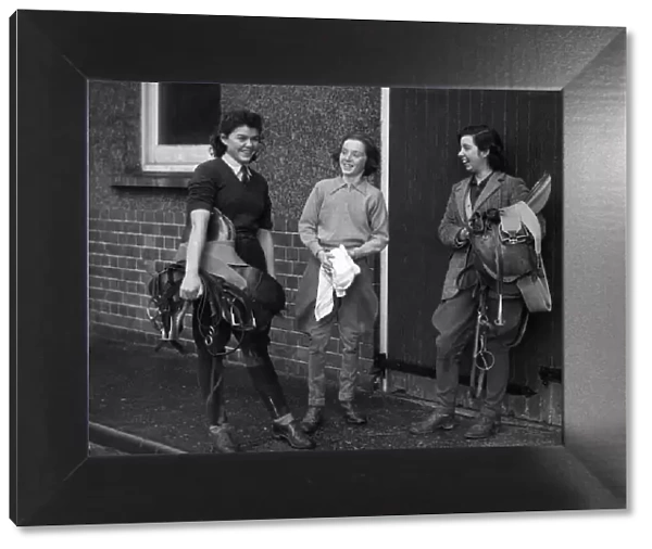 World War II Women. Three women in the land army prepare to go riding after a hard days