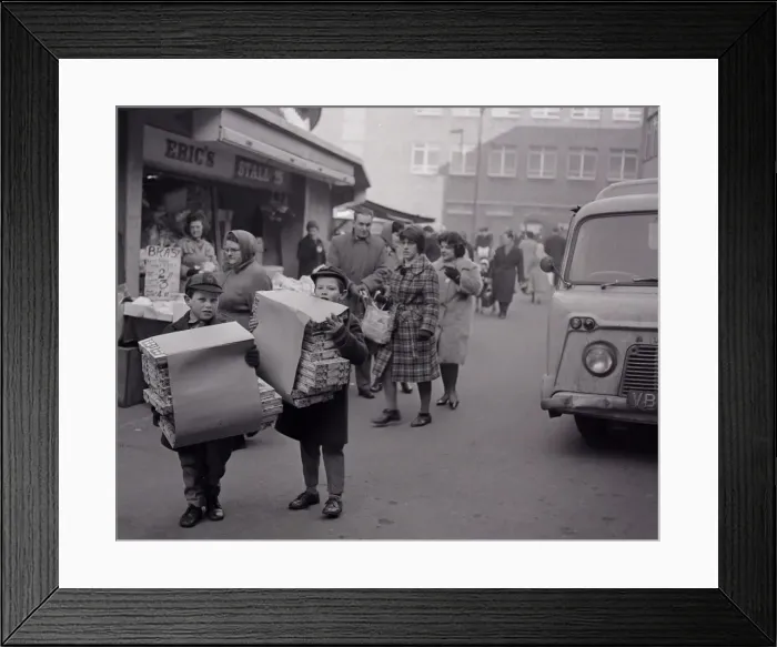 Framed Print : Two boys carrying boxes of Christmas crackers to help the festive season go off with a Framed Print : Two boys carrying boxes of Christmas crackers to help the festive season go off with a