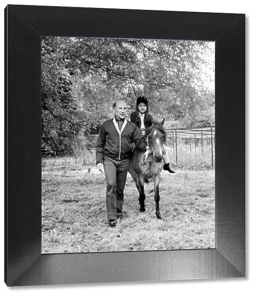 Sterling Moss (Ex Racing Driver). Seen here with horse and daughter