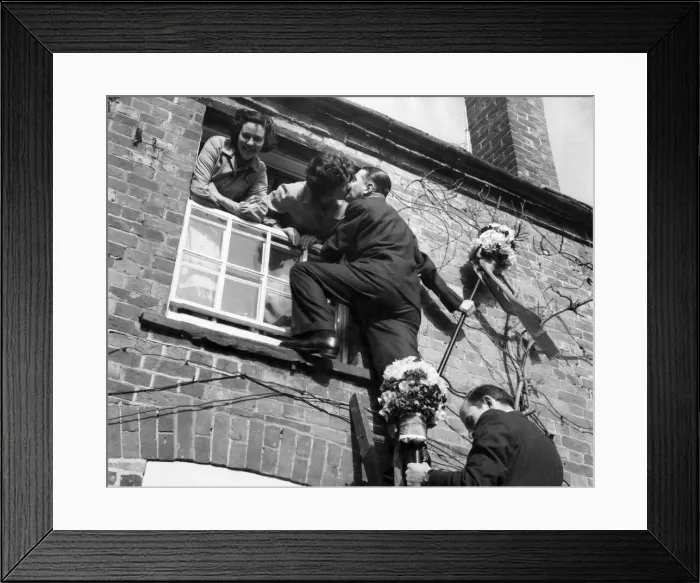 Framed Print : The tutti-men climb a ladder to get the traditional kiss the window during the Hock-tide Framed Print : The tutti-men climb a ladder to get the traditional kiss the window during the Hock-tide