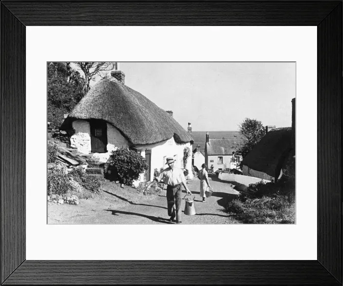 Framed Print : A man hauls a churn of milk up the main farafare in Clovelly