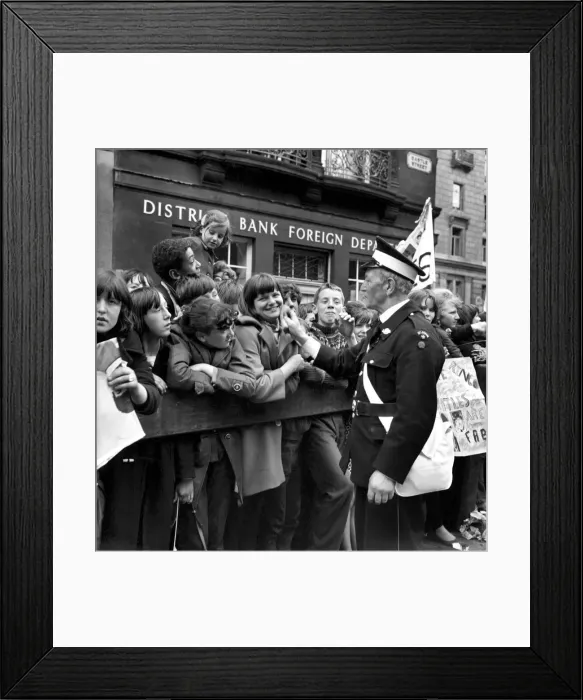 Framed Print : St Johns Ambulance worker checks on the well being of fans queuing in the streets of Framed Print : St Johns Ambulance worker checks on the well being of fans queuing in the streets of