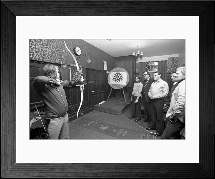 Framed Print : Archers challenge darts players to a game of darts, with the Archers using their bows Framed Print : Archers challenge darts players to a game of darts, with the Archers using their bows