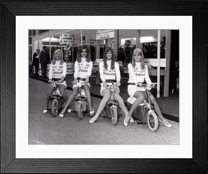 Framed Print : Business Efficiency Exhibition. Four mini-skirted messenger girls sit on their Electric Framed Print : Business Efficiency Exhibition. Four mini-skirted messenger girls sit on their Electric