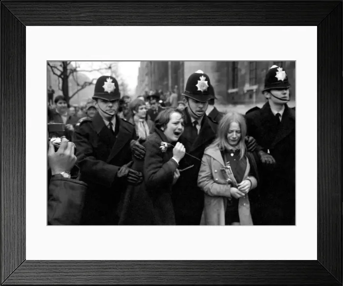 Framed Print : Two hysterical, weeping girls are led away from the steps of the register office by Framed Print : Two hysterical, weeping girls are led away from the steps of the register office by