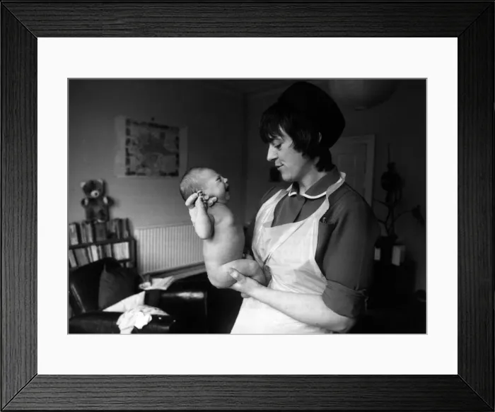 Framed Print : Midwife Lyz Simons with new born baby at a new parents home in Bristol Framed Print : Midwife Lyz Simons with new born baby at a new parents home in Bristol