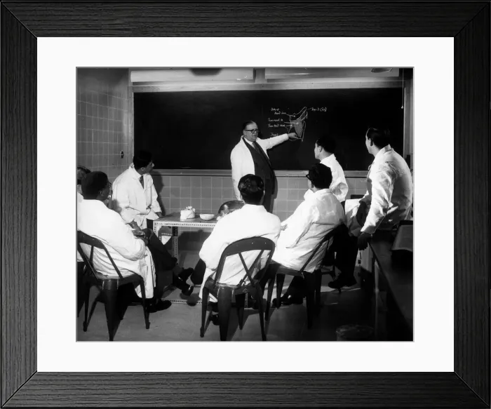 Framed Print : Trainee doctors being given instruction on the blackboard during a lecture Framed Print : Trainee doctors being given instruction on the blackboard during a lecture