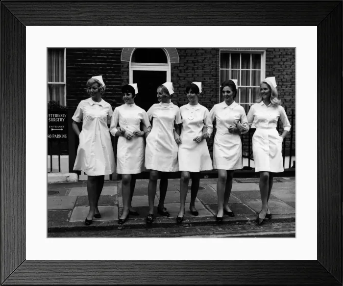 Framed Print : Models displaying six modern style white dresses for nurses at the London Nursing