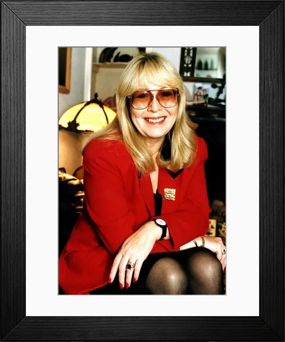 Framed Print : Cynthia Lennon wearing red jacket with arms on knees and dark glasses December 1995 Framed Print : Cynthia Lennon wearing red jacket with arms on knees and dark glasses December 1995