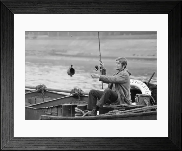 Framed Print : An angler from the Soho Firestation seen here fishing off a barge moored close to Framed Print : An angler from the Soho Firestation seen here fishing off a barge moored close to