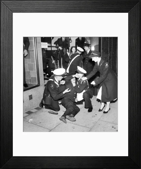 Framed Print : Ambulance men and medical workers attend to a Beatles fan who was injured in a crush as