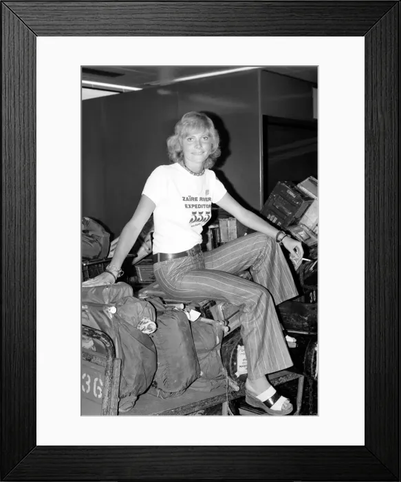 Framed Print : Zaire River Expedition Returns: Nurse Pam Baxter sitting on her luggage at Gatwick Framed Print : Zaire River Expedition Returns: Nurse Pam Baxter sitting on her luggage at Gatwick