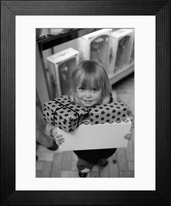 Framed Print : Three year old Mandie Keating of Boreham Wood with her arms full of parcels doing some