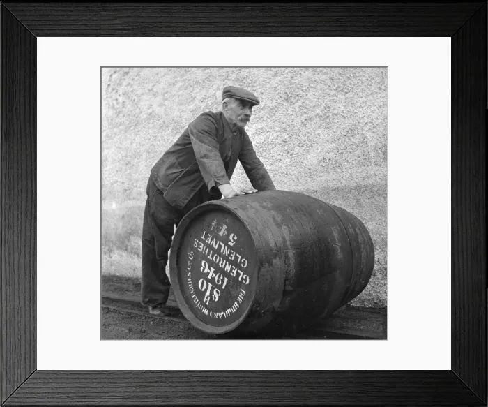 Framed Print : A Glenlivet Distillery worker rolls a barrel of their finest single malt whisky to