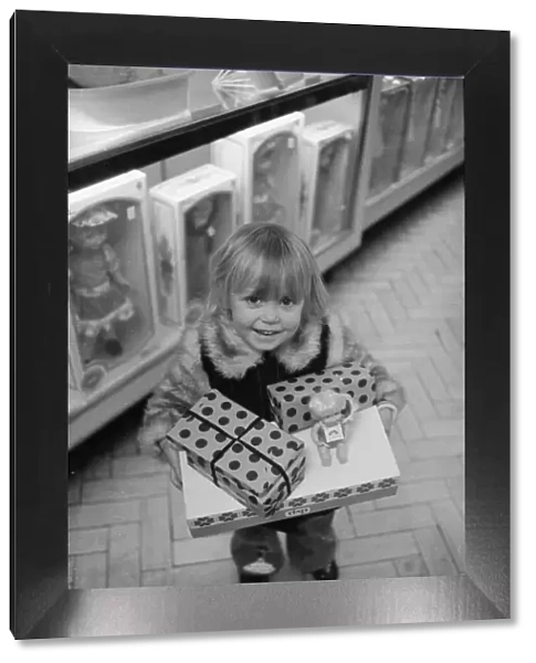 Three year old Mandie Keating of Boreham Wood with her arms full of parcels doing some