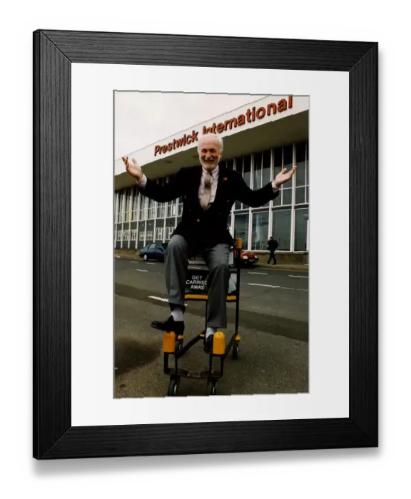 Framed Print : Matthew Hudson sitting on luggage trolly with hands in the air outside Prestwick Airport Framed Print : Matthew Hudson sitting on luggage trolly with hands in the air outside Prestwick Airport