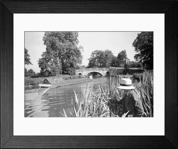 Framed Print : A young angler wearing a panama hat fishing in the Grand Union Canal between Framed Print : A young angler wearing a panama hat fishing in the Grand Union Canal between