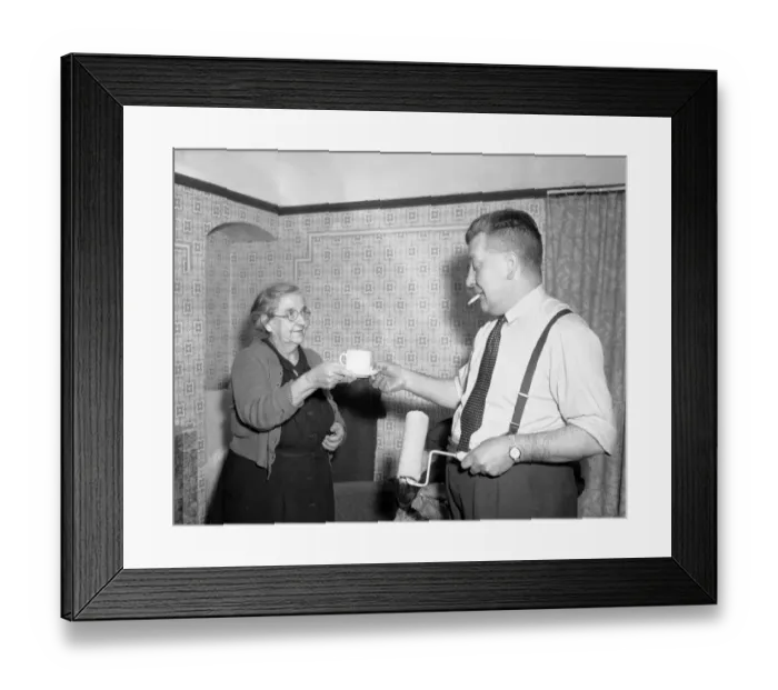 Framed Print : House wife hands her husband a cup of tea whilst he takes a break from the painting