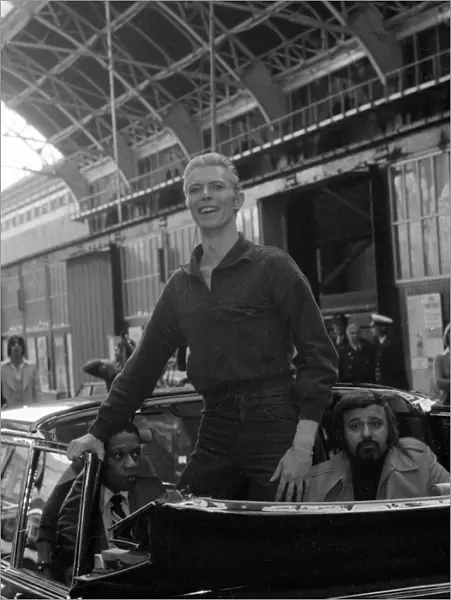 Pop singer David Bowie smiles as he arrives at Victoria Station in London May 1976