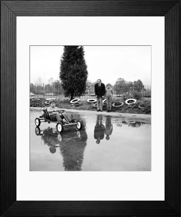 Framed Print : ChildrenIs Go-kart: Richard Spicer aged 5, driving the Kiddies Go Kart watched by Roy