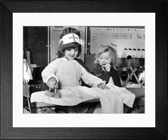 Framed Print : Even a nurse has to get her ironing done as Michelle Tiplady shows with help from Jane