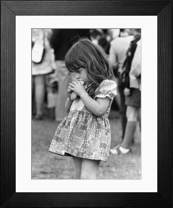 Framed Print : This little girl is enjoying her hot dog more than the occassion