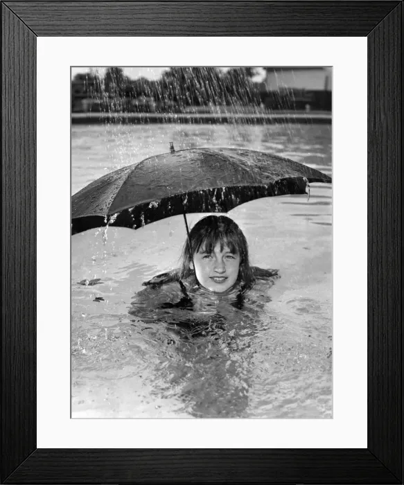 Framed Print : This holiday maker is determined to make the best of her holiday whatever the weather