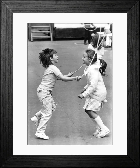 Framed Print : Two youngsters enjoying playtime with a spot of skipping Framed Print : Two youngsters enjoying playtime with a spot of skipping