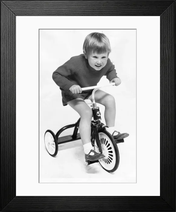 Framed Print : A young boy enjoying a ride on his tricycle Framed Print : A young boy enjoying a ride on his tricycle