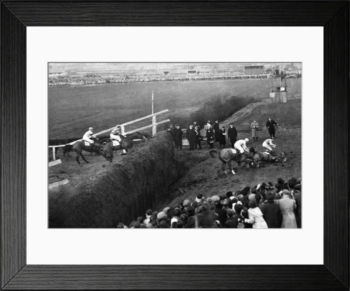 Framed Print : Grand National: The horse lying third falls; on fourth horse falls  /  third