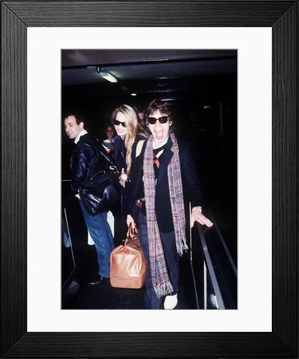 Framed Print : Rolling Stones singer Mick Jagger at London Heathrow Airport with Jerry Hall before