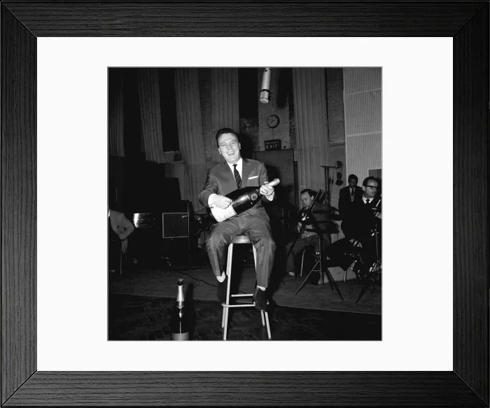 Framed Print : Matt Monro sitting on stool in recording studio holding bottle of champagne