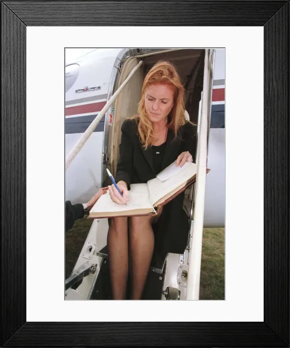 Framed Print : Duchess of York Sarah Ferguson signs the visitors book at the airport before her flight Framed Print : Duchess of York Sarah Ferguson signs the visitors book at the airport before her flight