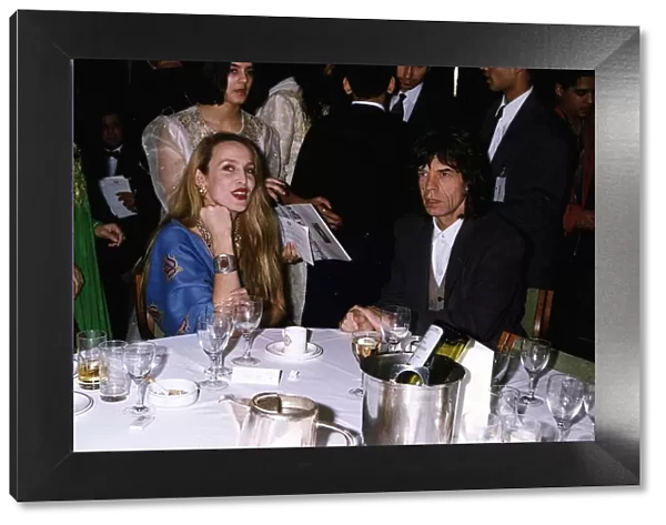 Mick Jagger Singer with wife Jerry Hall sitting at table a gala night