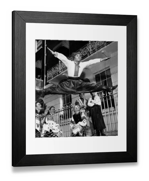 Framed Print : Ukranian dancer Dmytro Paraduik legs open wide as he leap over three girls as they