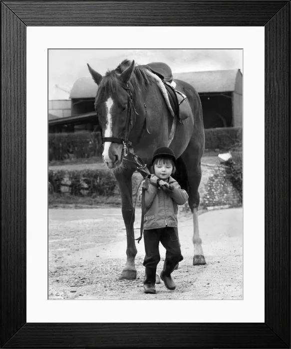 Framed Print : Two and a half year old Julie Bainbridge has made up her mind to ride in the grand