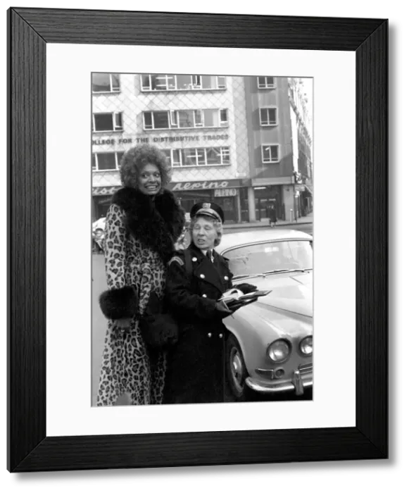 Framed Print : Model Lorne Lesley wearing a long leopard skin coat with fur collar standing behind a
