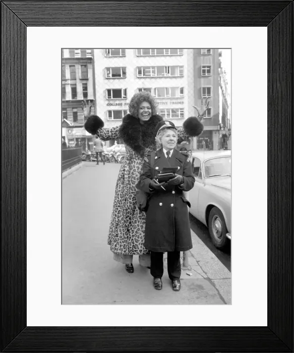 Framed Print : Model Lorne Lesley wearing a long leopard skin coat with fur collar standing behind a Framed Print : Model Lorne Lesley wearing a long leopard skin coat with fur collar standing behind a