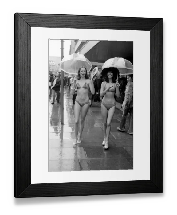 Framed Print : Models Wendy and Jackie seen here modeling the latest in swimwear on a wet Oxford Street