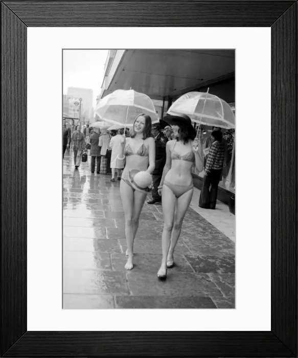 Framed Print : Models Wendy and Jackie seen here modeling the latest in swimwear on a wet Oxford Street