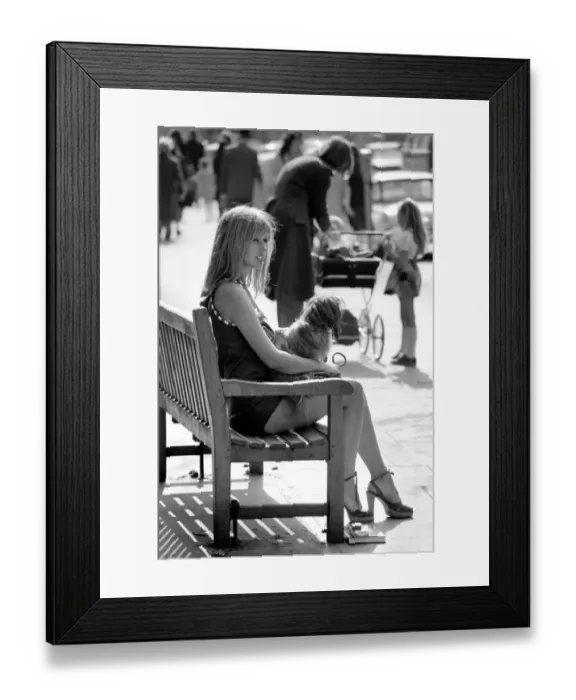 Framed Print : Woman taking her dog for a walk on Kings Road in Chelsea, sitting down on a bench