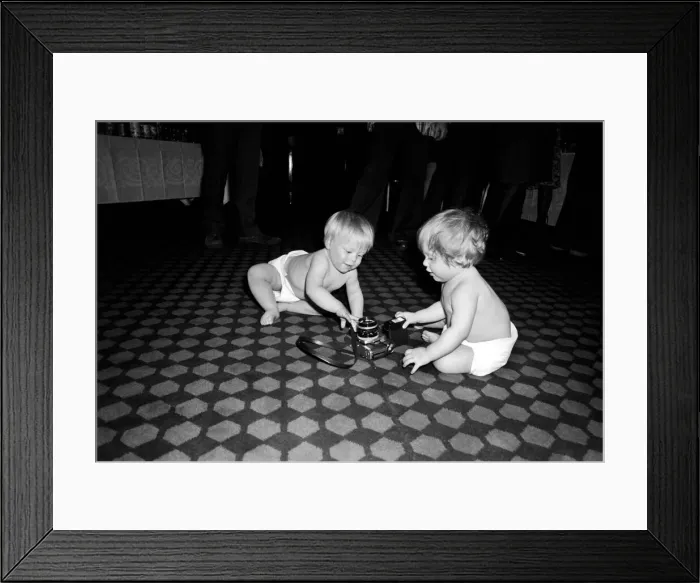 Framed Print : Two young babies seen here examining a camera at a gathering of them parents of a West Framed Print : Two young babies seen here examining a camera at a gathering of them parents of a West
